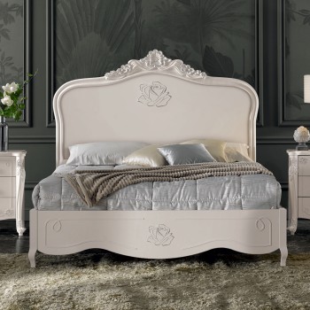 Letto elegante con testata intagliata e decorazioni floreali
