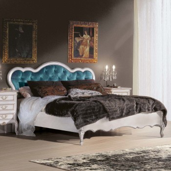 Letto imbottito con particolari intagliati, testata capitonnè blu