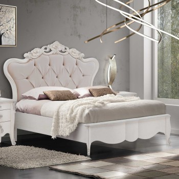 Letto matrimoniale con testata intagliata imbottita capitonnè, dettaglio di design barocco